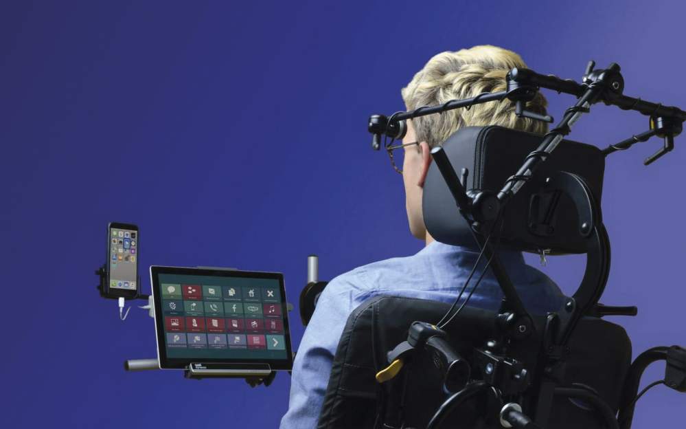 Un homme dans une chaise avec son GSM et sa tablette