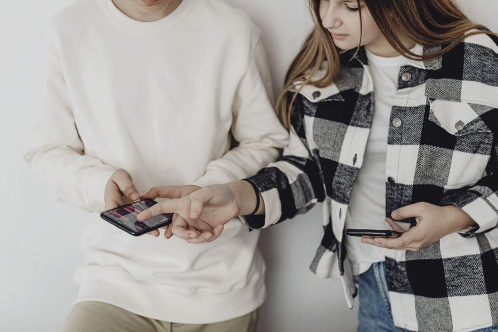 deux adolescents regardent leur smartphone