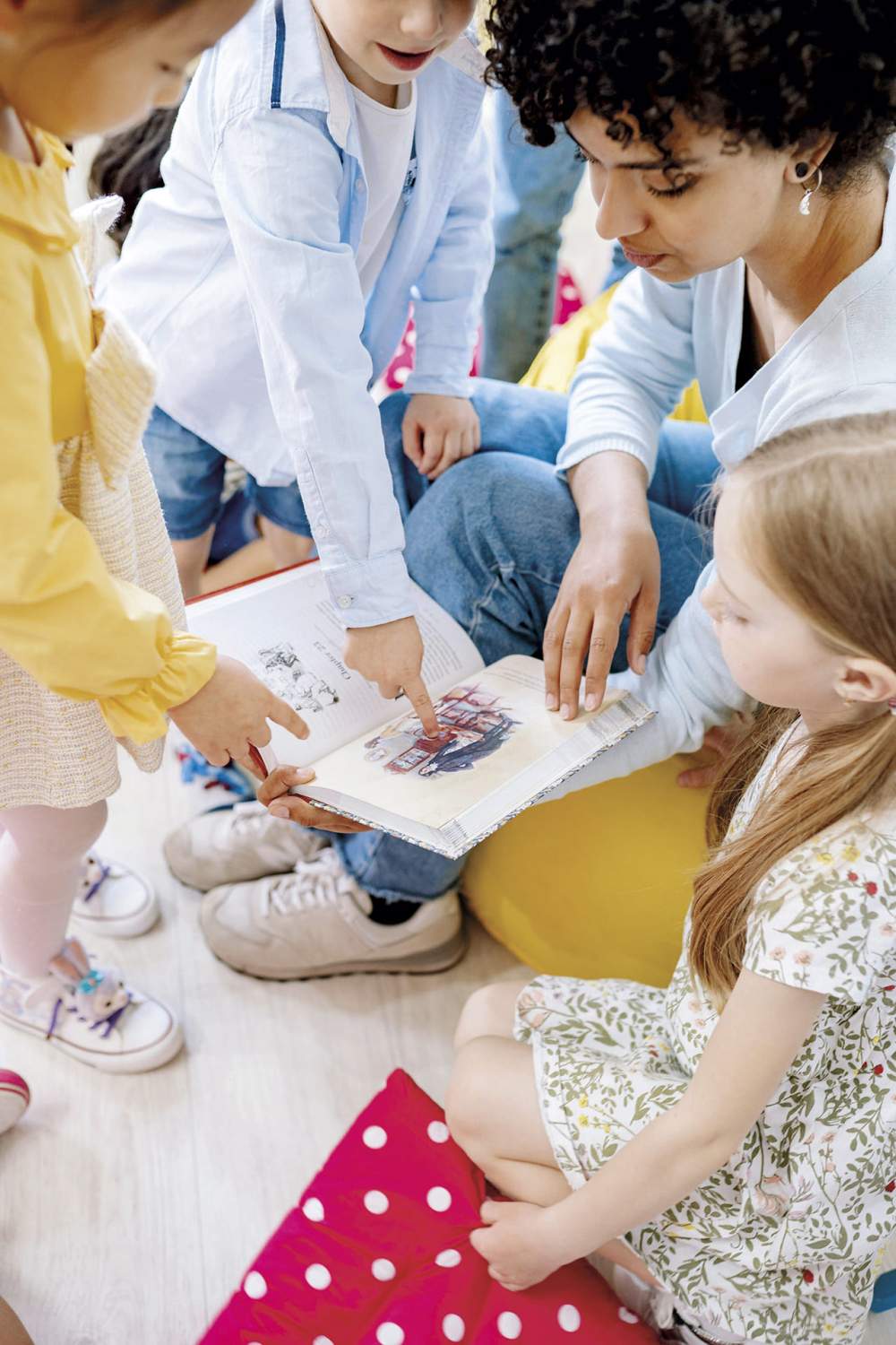Une éducatrice partage un moment lecture avec des jeunes élèves