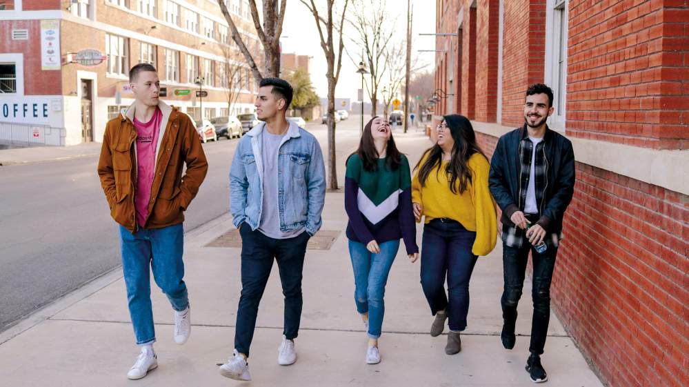 5 étudiants marchant dans une rue.